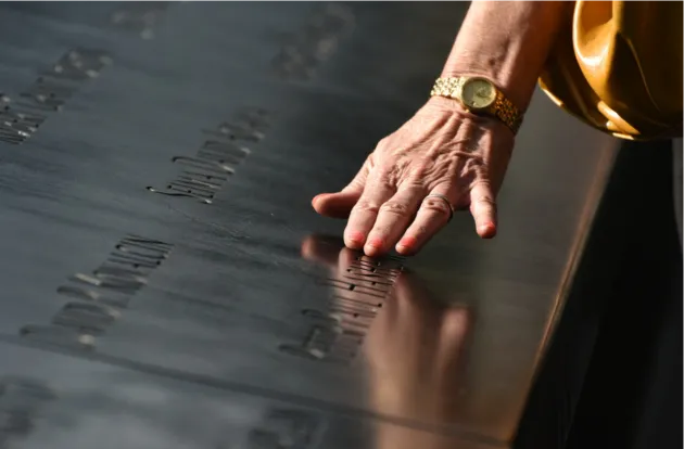 la mano de una mujer acariciando memoria lápida.